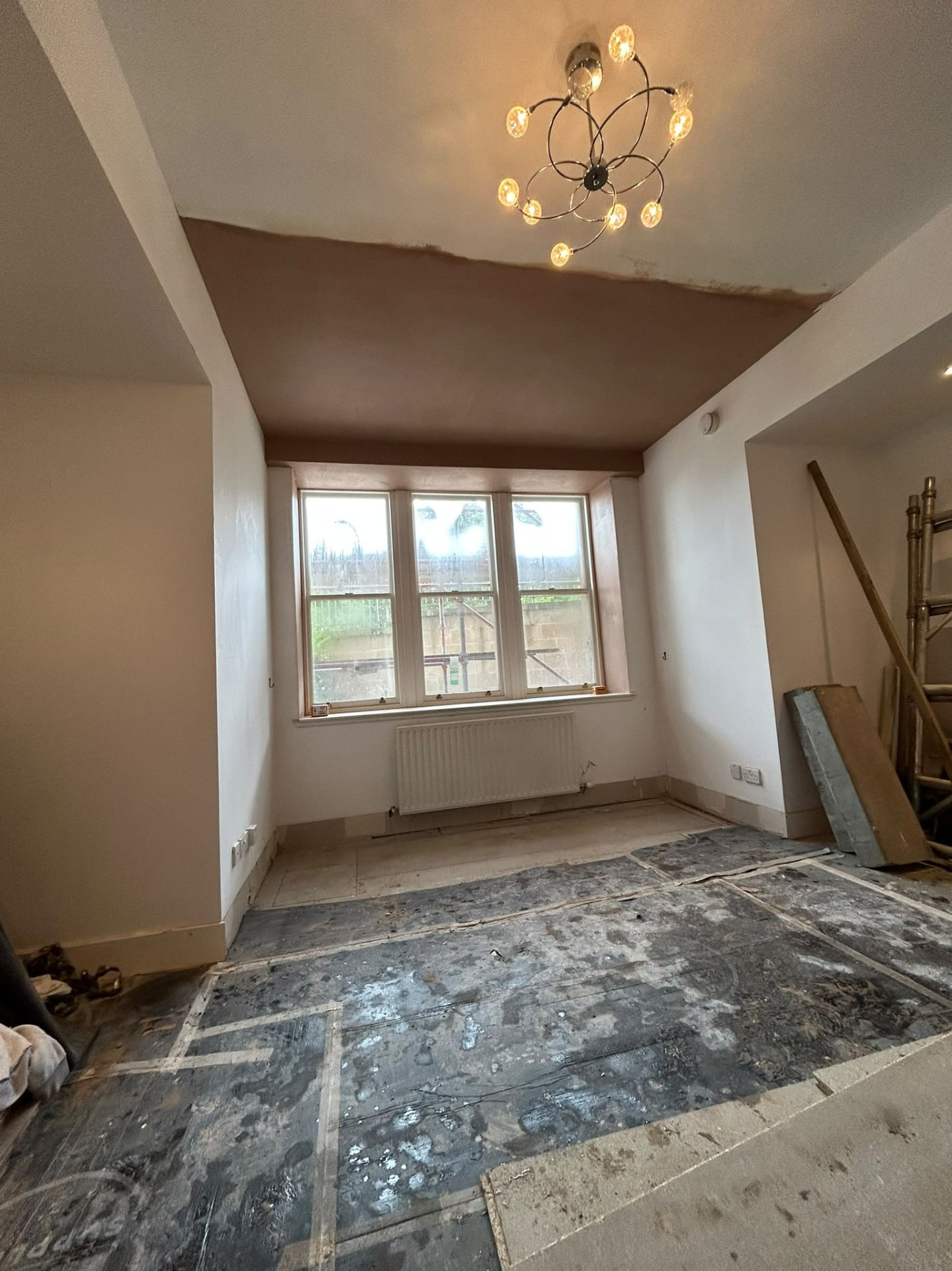 Bay window room with the ceiling stripped back and freshly plastered smooth after Artex removal