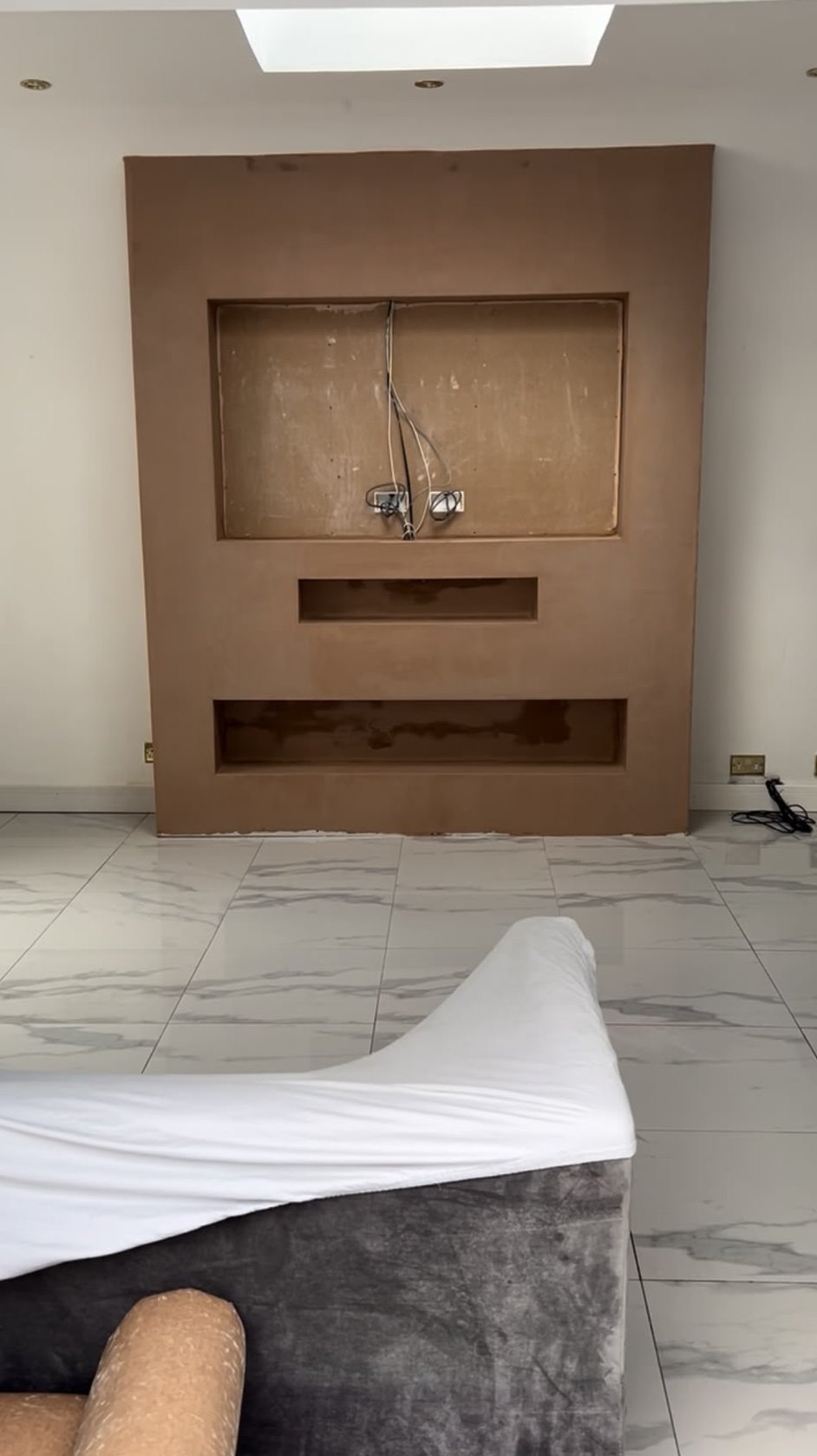 Freshly skimmed media wall with recessed openings for a television, soundbar and fire
